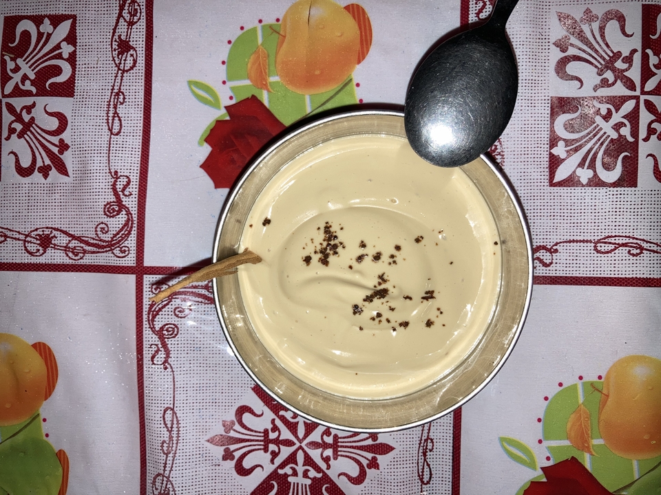 Small bowl of custard dessert with a spoon.