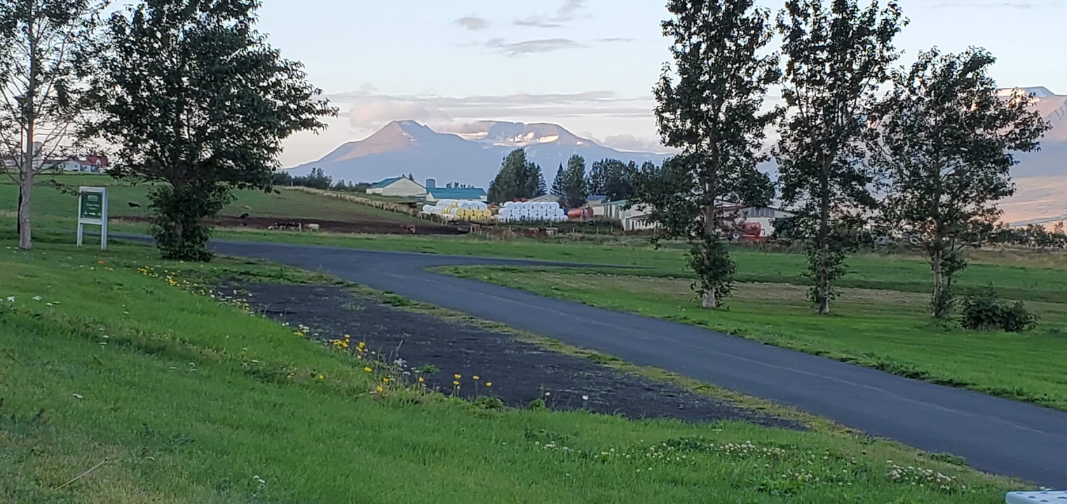 Rural landscape with mountains and a paved road.