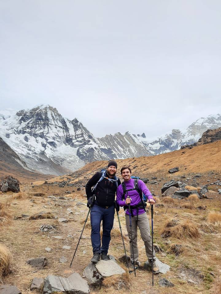 Deux randonneurs posant avec des bâtons de randonnée en terrain montagneux.
