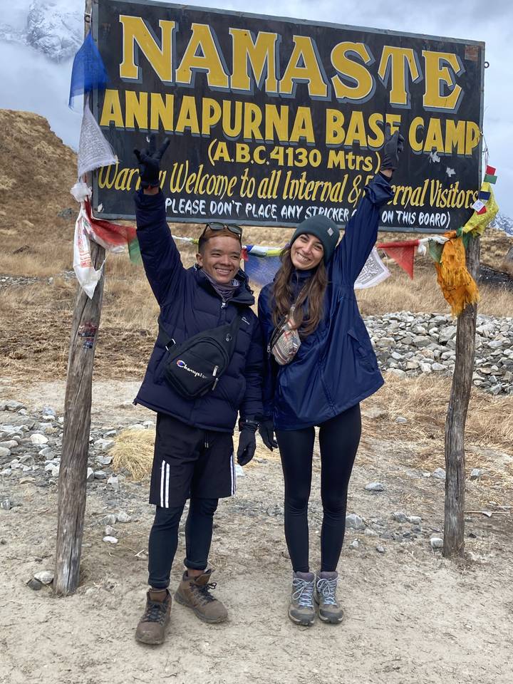 Deux personnes posent avec un panneau au camp de base de l'Annapurna.