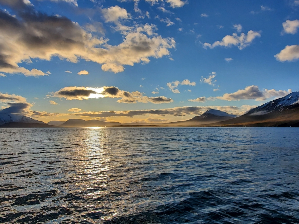 Scenic view of a lake surrounded by mountains at sunset.