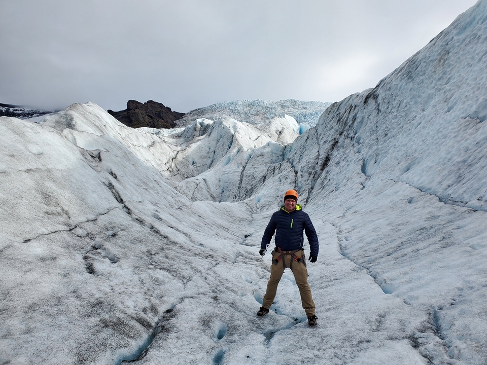 Person standing on a glacier landscape.