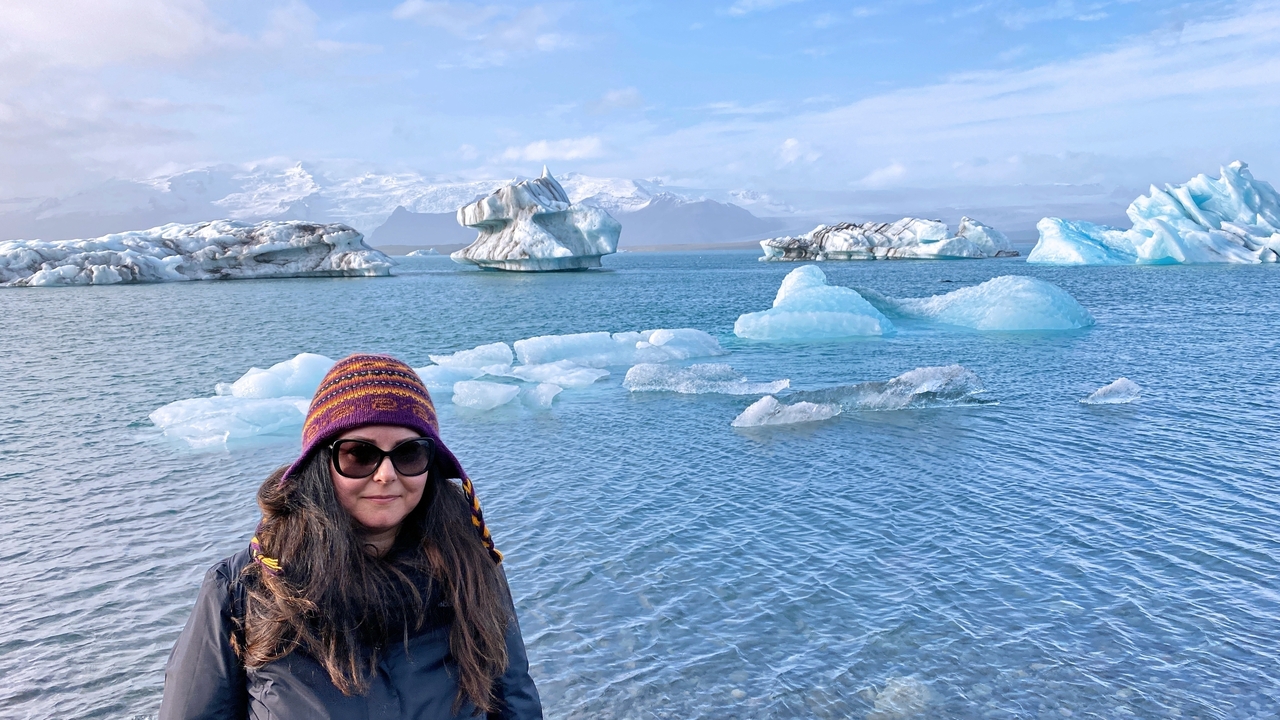 Woman standing by a lagoon with icebergs.