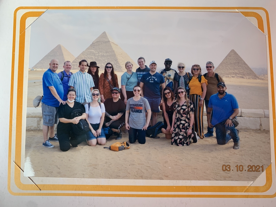 Group of people posing in front of the pyramids.