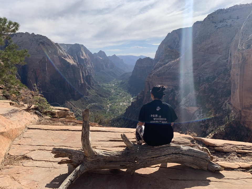 Person sitting on a rock overlooking a valley