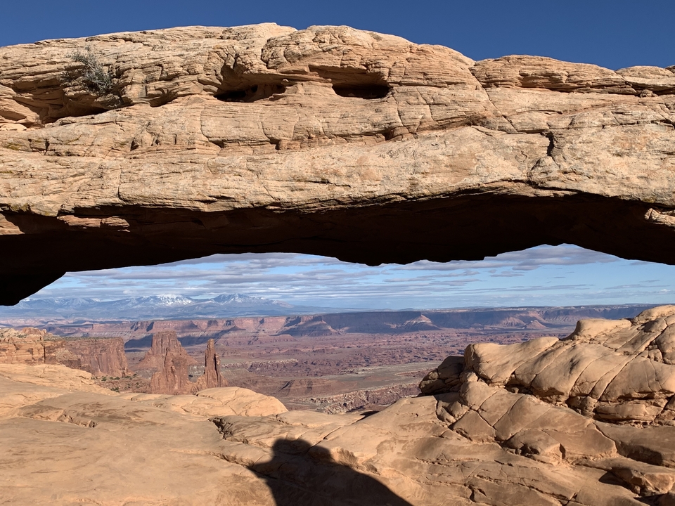 Rock arch framing a view of canyon landscape