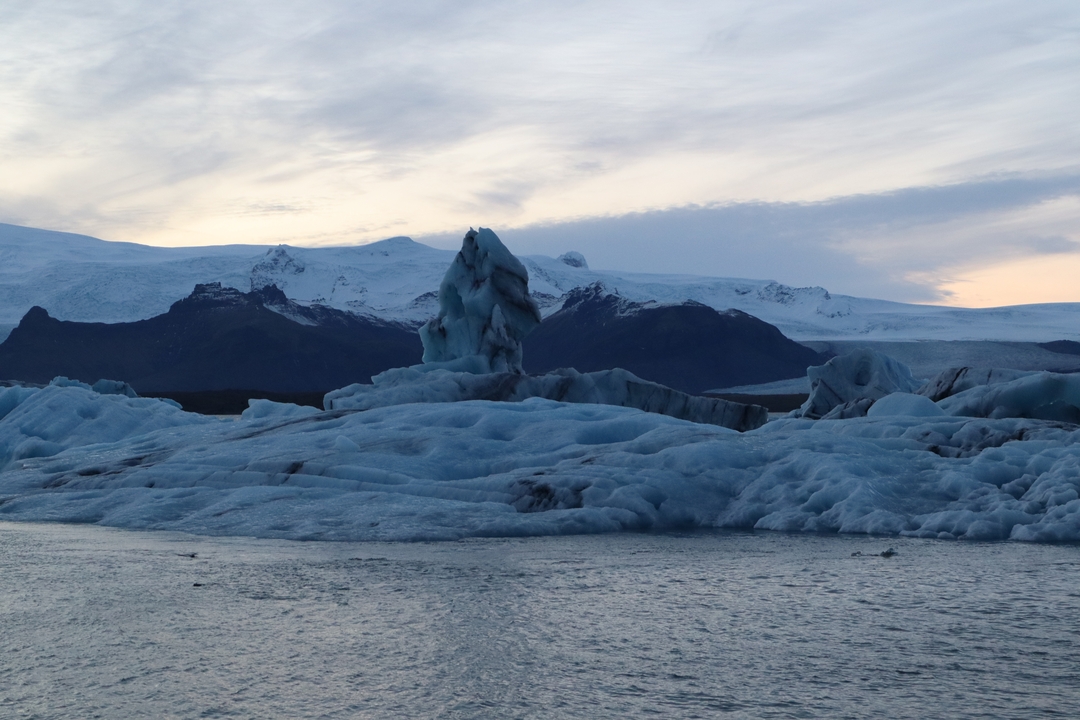 Des icebergs flottant dans un cadre d'eaux glacées sereines au coucher du soleil.
