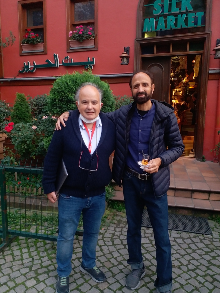 Deux hommes posant ensemble dans un jardin.