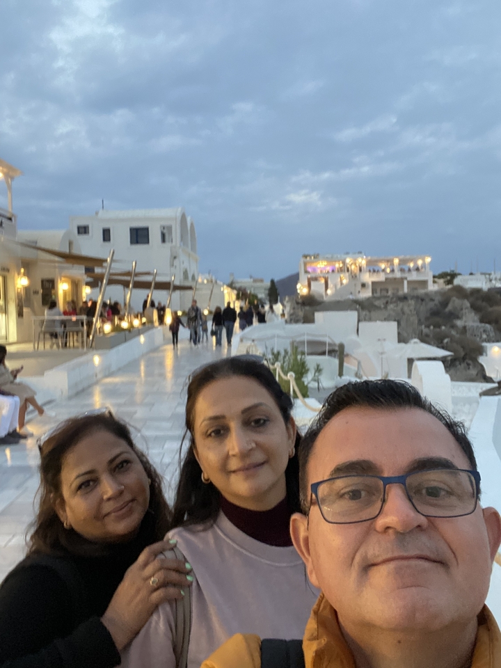 Trois personnes avec un arrière-plan d'architecture blanche typique de Santorin.