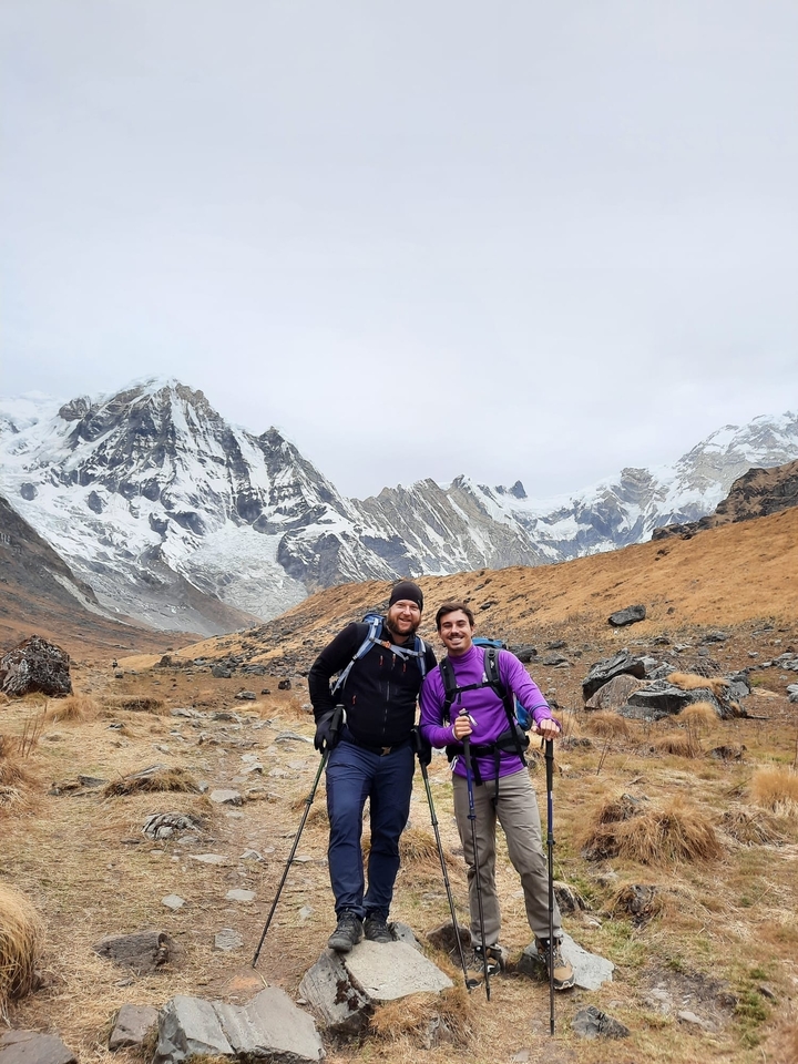 Deux randonneurs posant devant des montagnes enneigées.