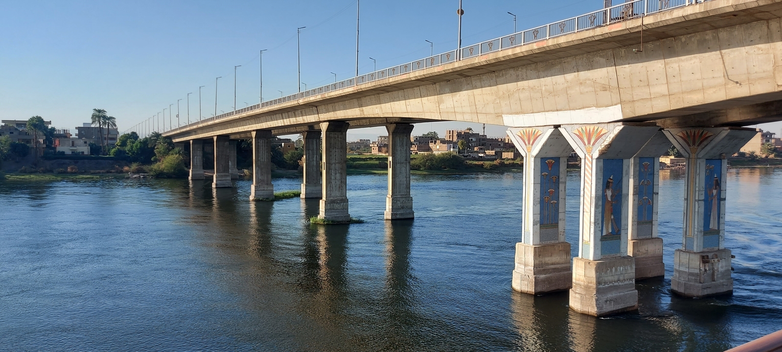 Bridge over a river with decorative pillars and blue skies.