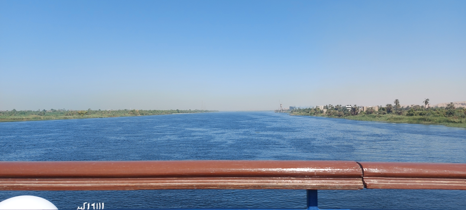 River view with distant banks and clear blue sky.