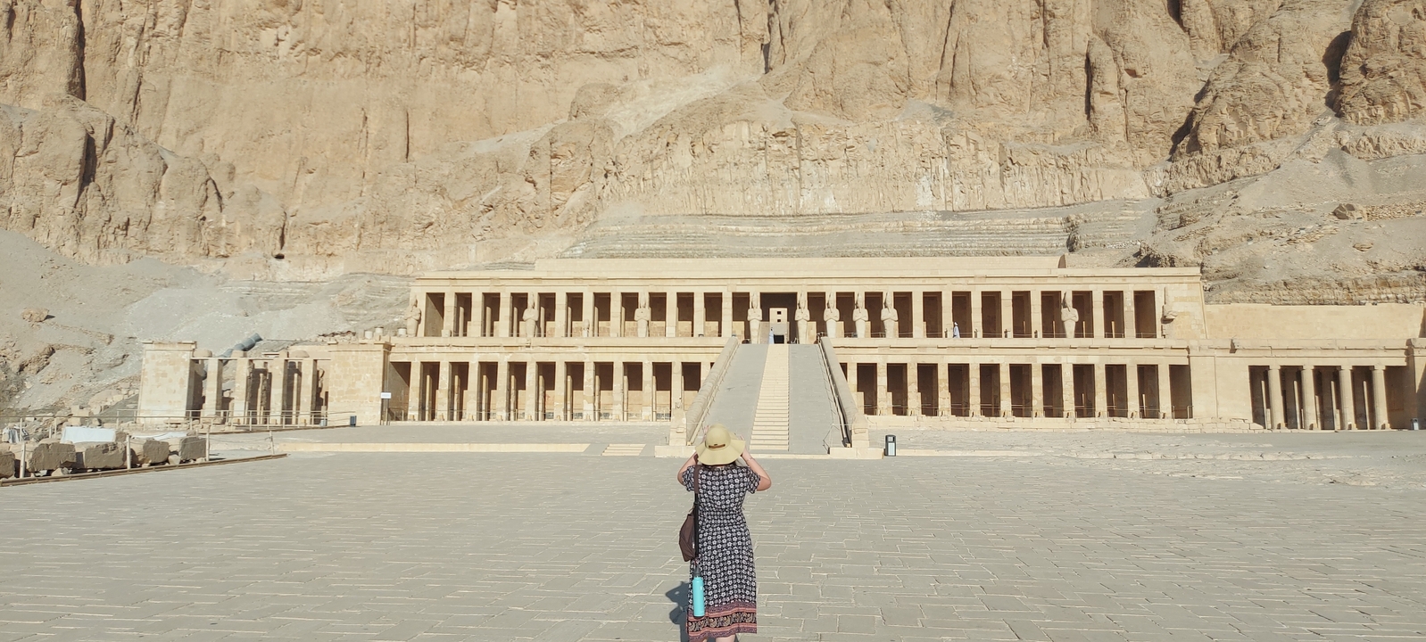 Wide view of an ancient temple facade with a lone visitor.