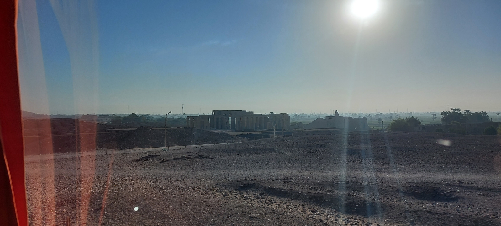 View of an open desert landscape with a distant temple.