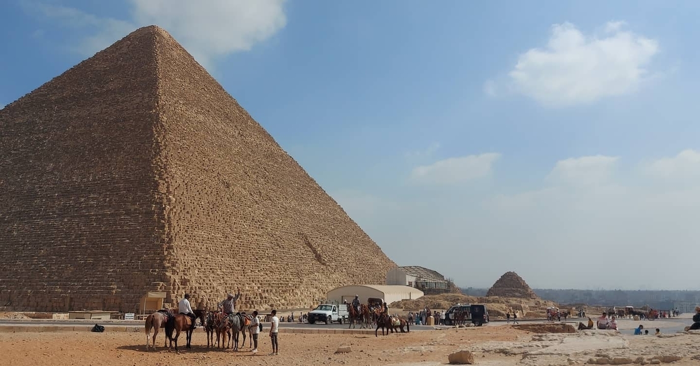 Horses and camels with riders near the Pyramids of Giza.