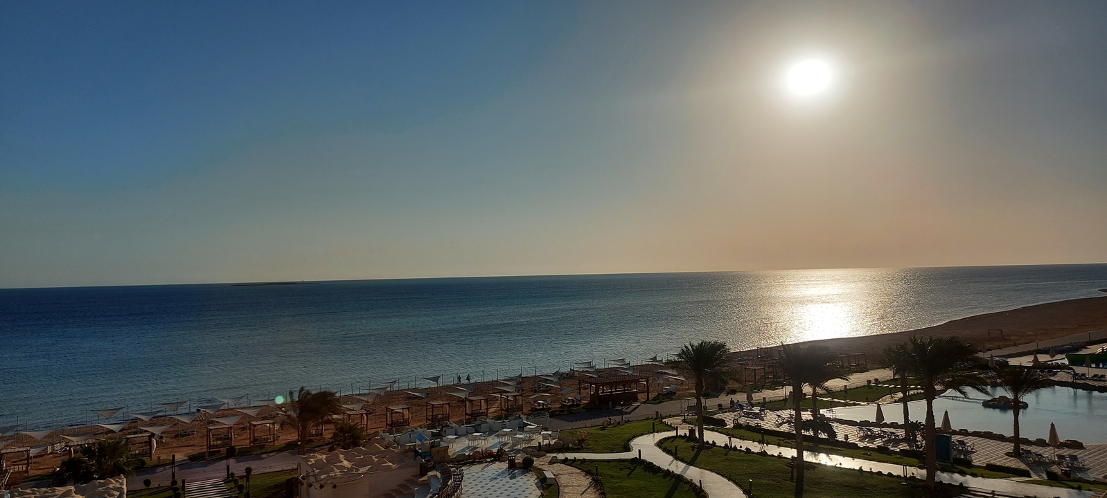 Beachfront resort with views of the sea at sunset.