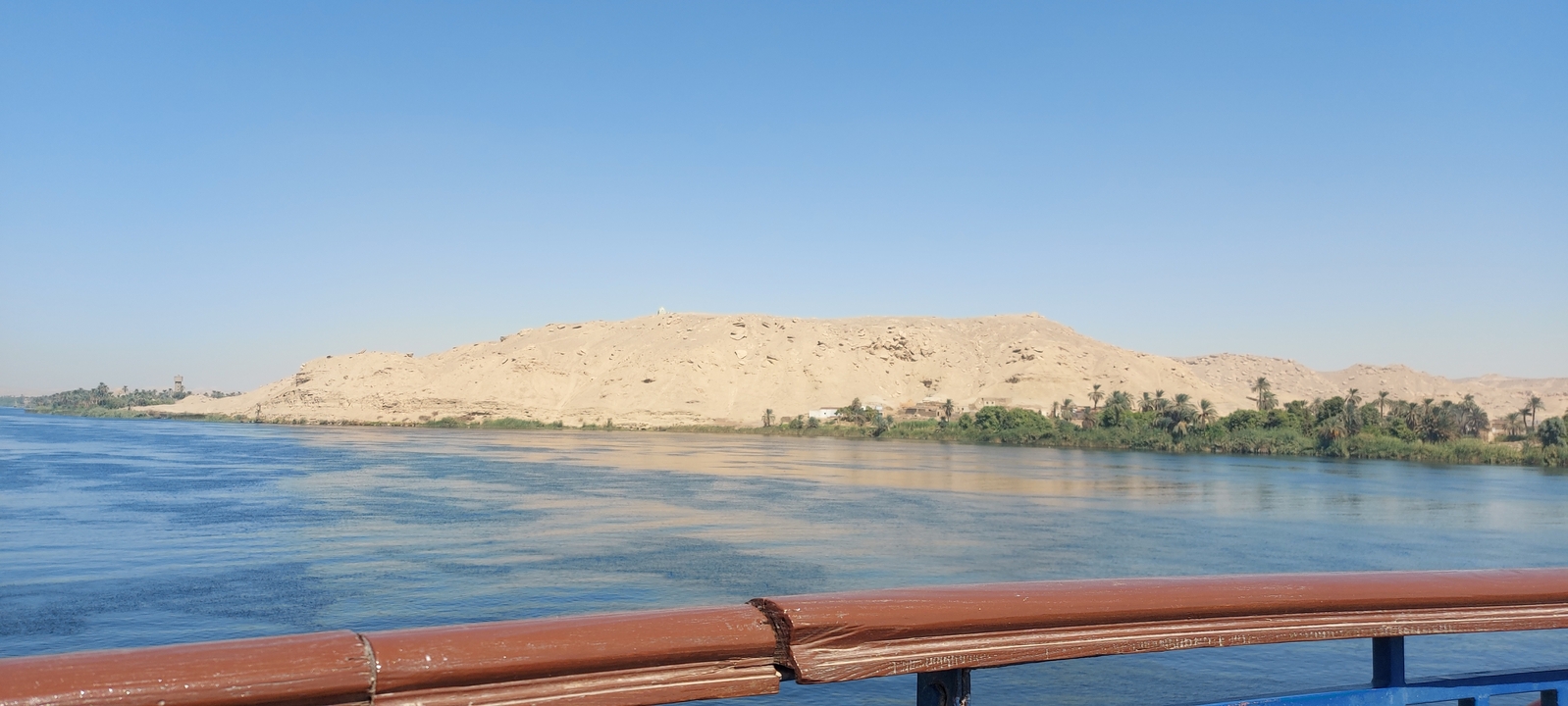 River view with a sandy bank and clear blue sky.