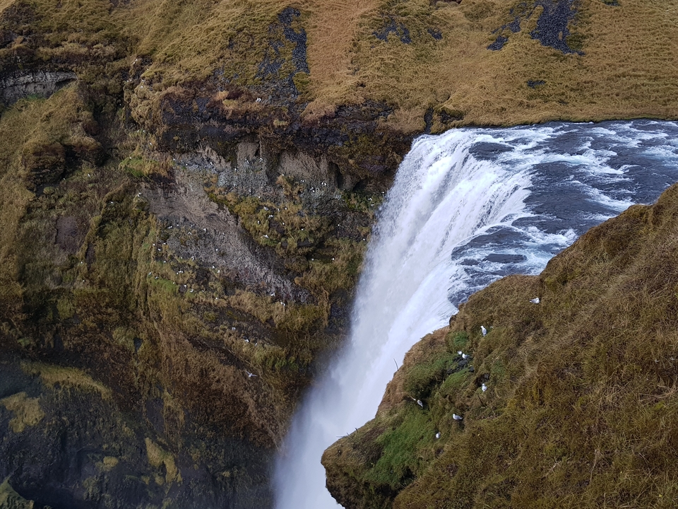 Cascade tombant d'une falaise escarpée dans un bassin.