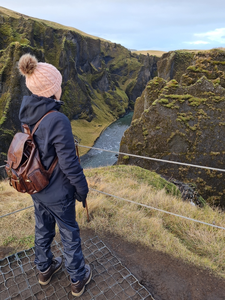 Personne debout sur une falaise surplombant une rivière sinueuse.