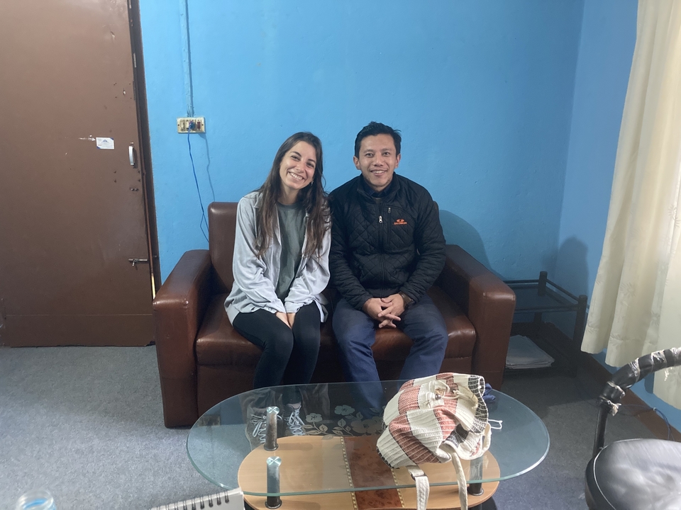 Deux personnes assises sur un canapé dans une pièce avec des murs bleus.