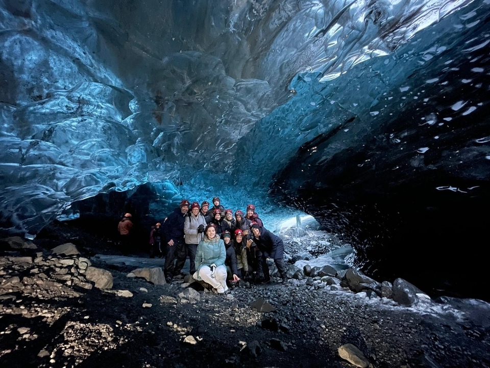 Un groupe dans une grotte de glace portant des vêtements chauds.