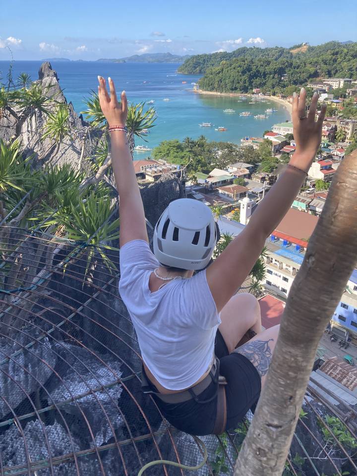 Individual excitedly posing with a view of the bay below.