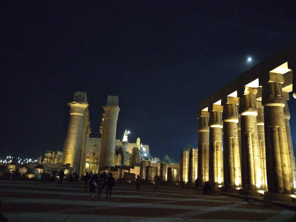 Ancient columns and buildings lit up at night.