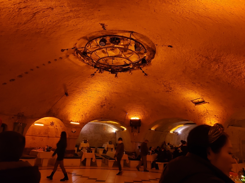 Interior of a cave or underground setting with warm lighting.