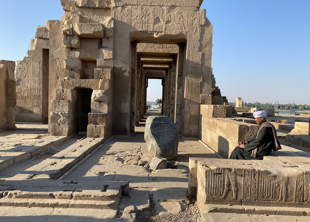Historic temple with a person sitting in foreground.