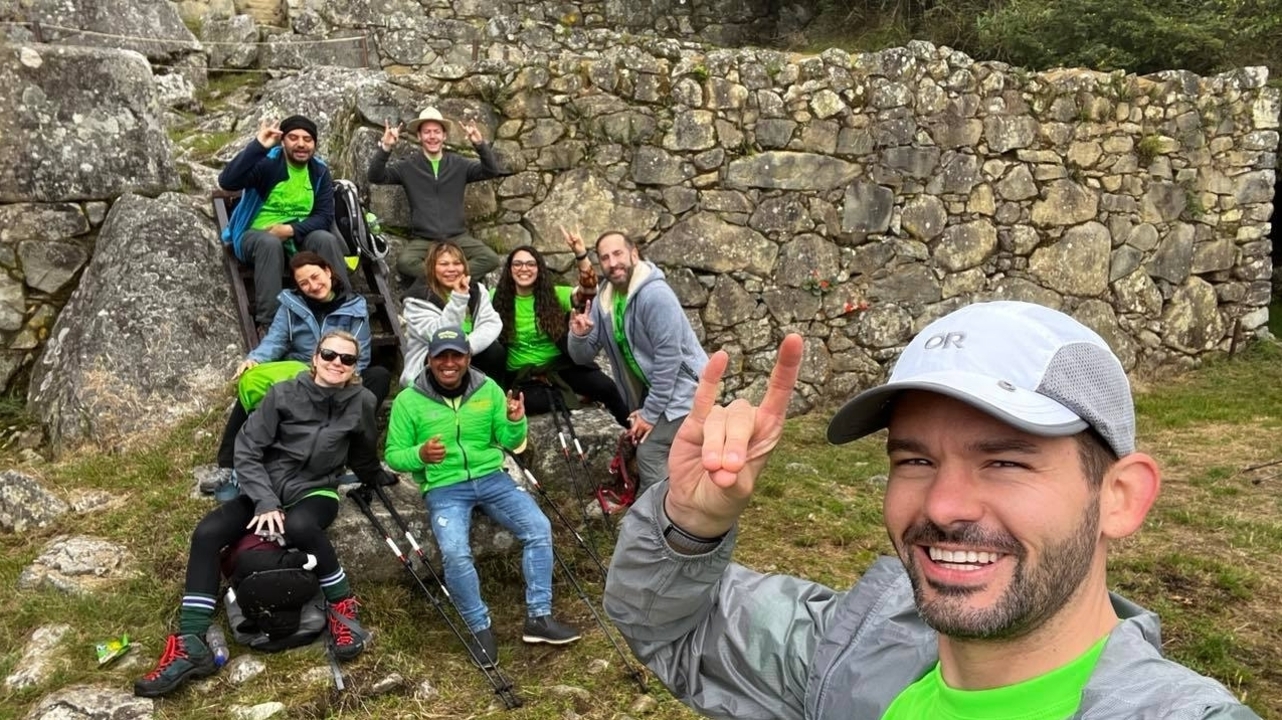 Group of people posing with joy near ancient stone ruins.