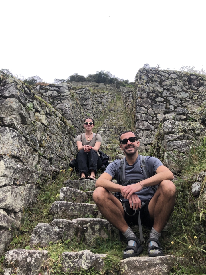 Two people sitting on ancient stone steps.