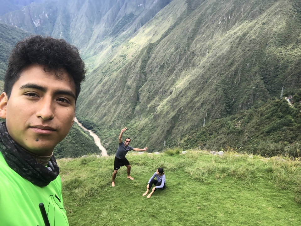 People posing on a grassy hill with valleys behind.
