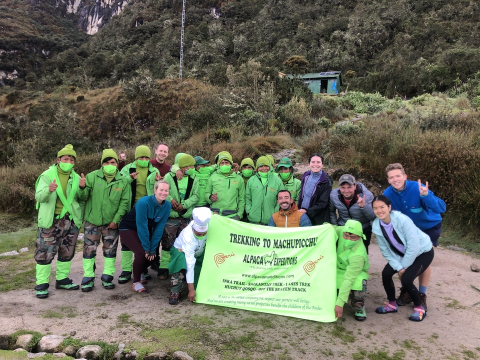 Group posing with a banner in a natural setting.