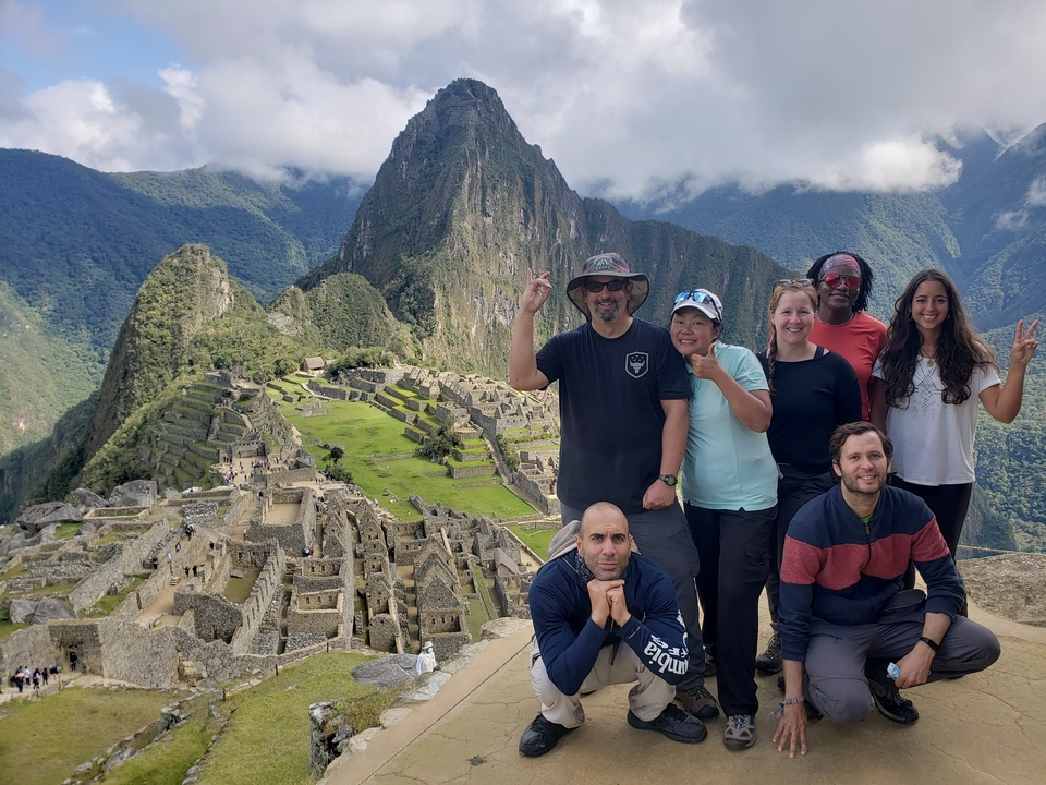 Group posing at Machu Picchu with the iconic mountain in the background.