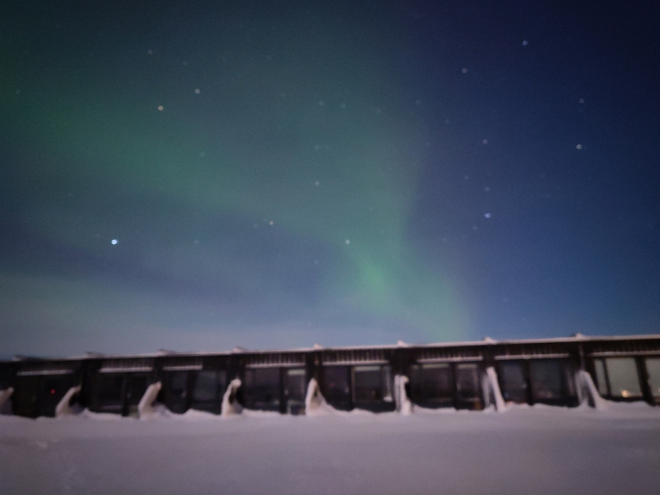 Auroras boreales sobre una serie de estructuras por la noche.