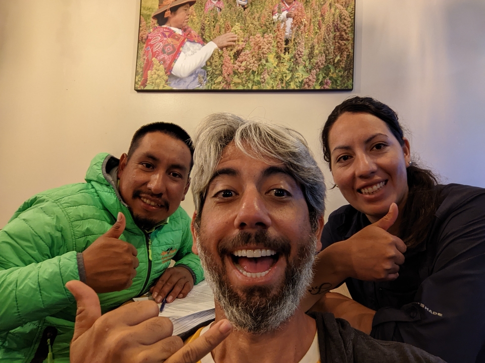 Three people indoors giving thumbs up.