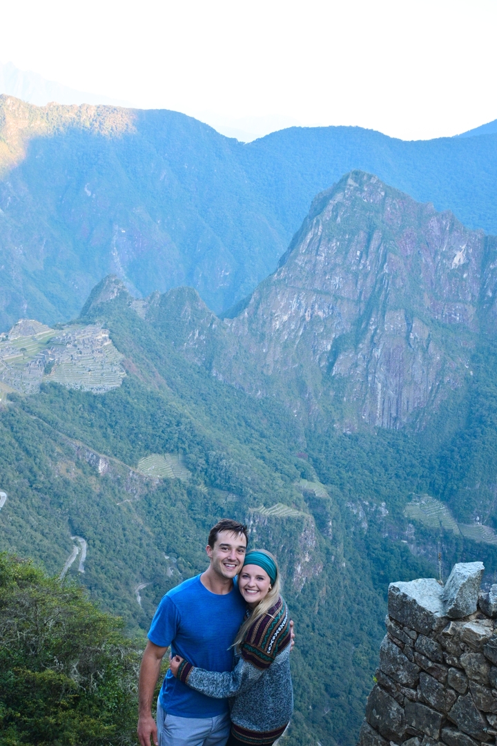 Distant view of Machu Picchu amidst lush mountains.