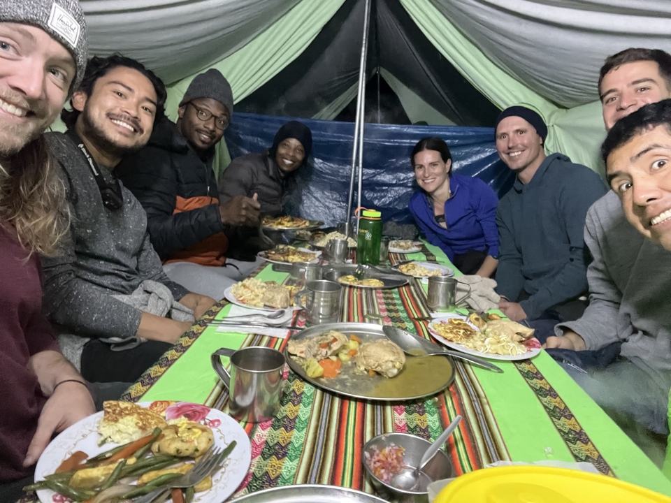 A group enjoying a meal inside a tent.