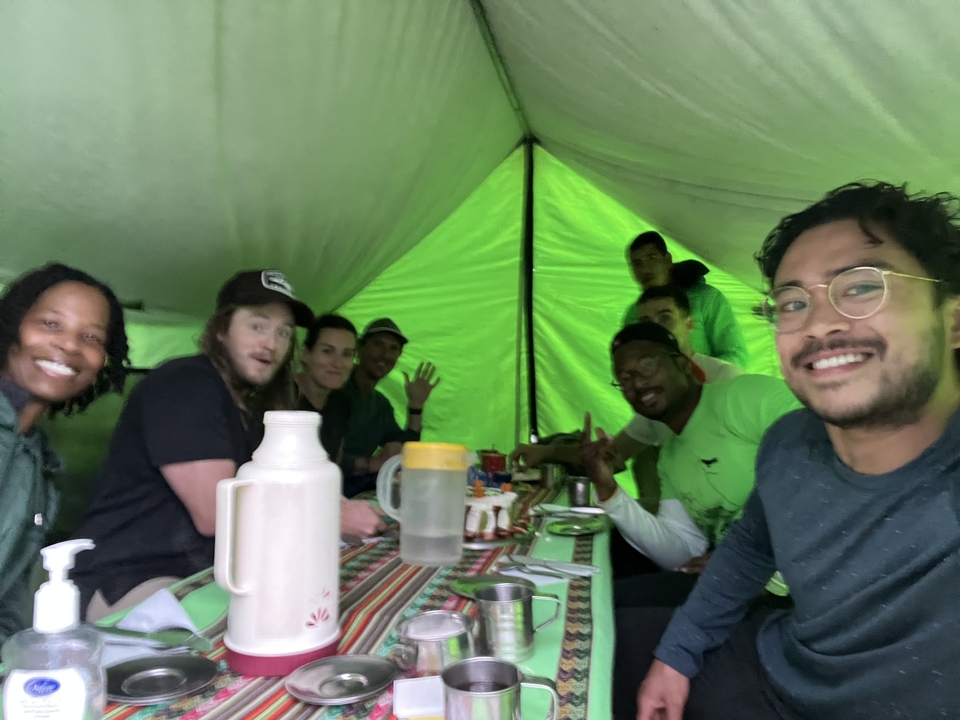 A group of people dining inside a tent.