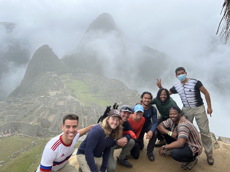 Group of people posing with Machu Picchu in the background.