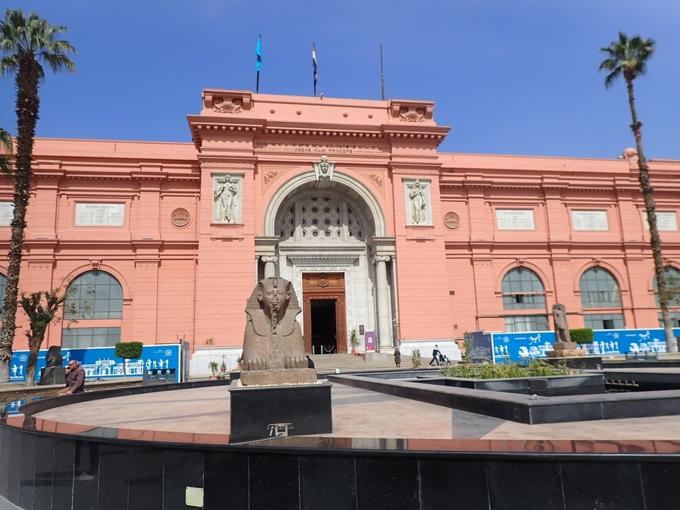 Front view of a museum with a sphinx statue in front.