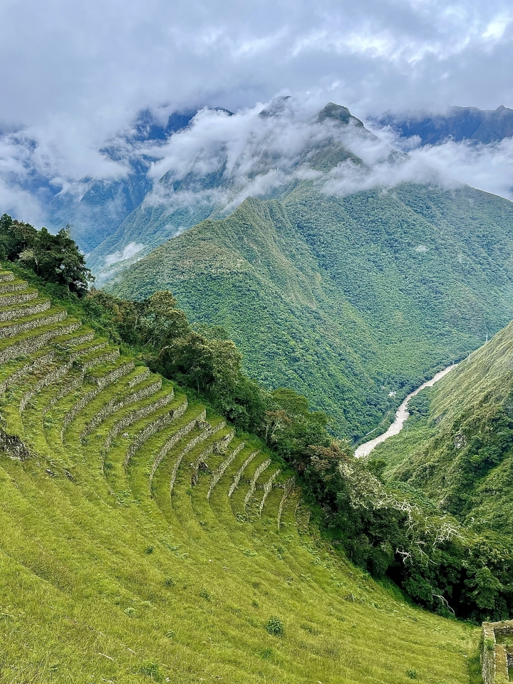 Terraced fields on a mountain slope overlooking a valley.