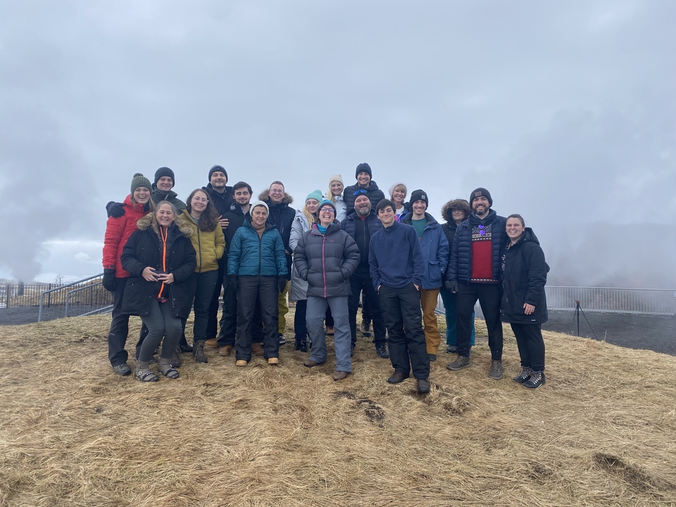 Group of people posing outdoors in a misty environment.