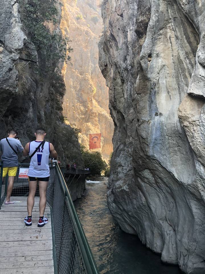 Vue pittoresque d'une gorge avec un pont et des gens.