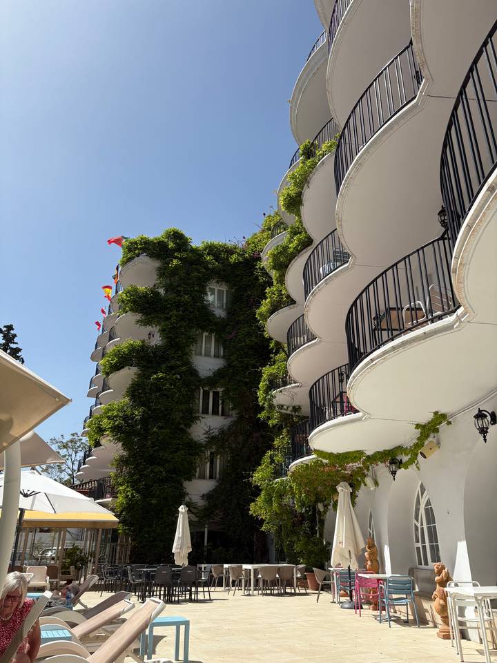 Vertical view of a building with green foliage.