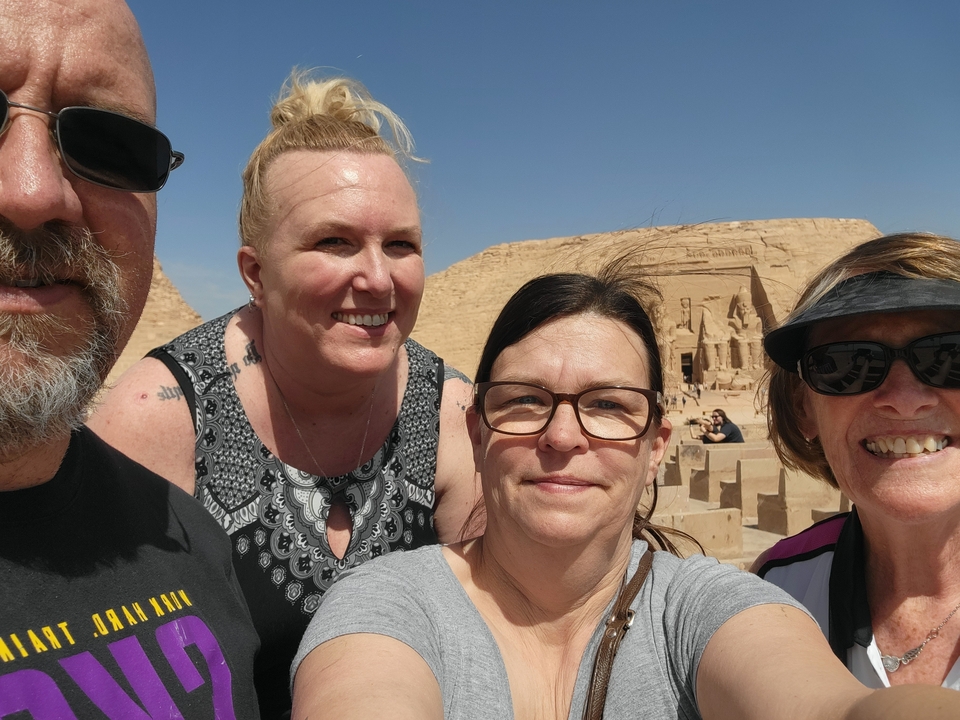 Group of people taking a selfie with Egyptian temples in the background.