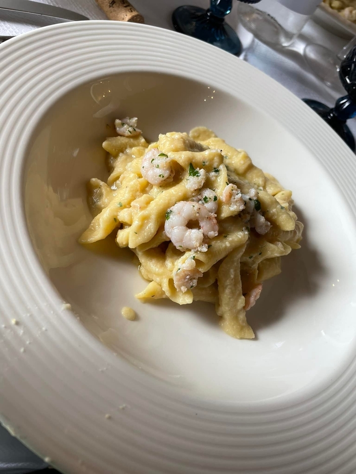 Plate of cooked pasta with shrimp and herbs.