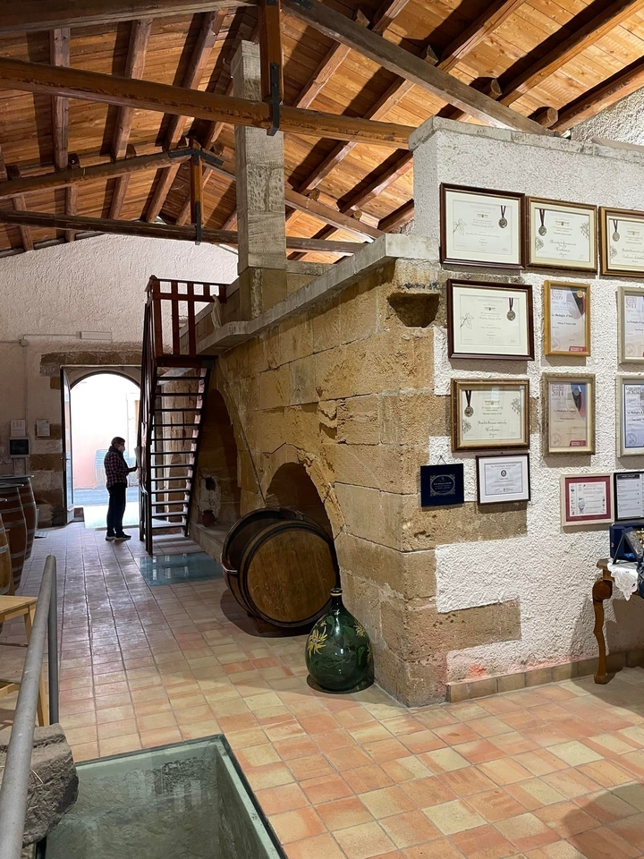 Interior of a building with wooden staircase and awards on the wall.