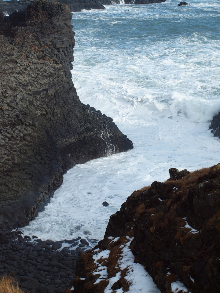 Olas estrellándose contra una costa rocosa.