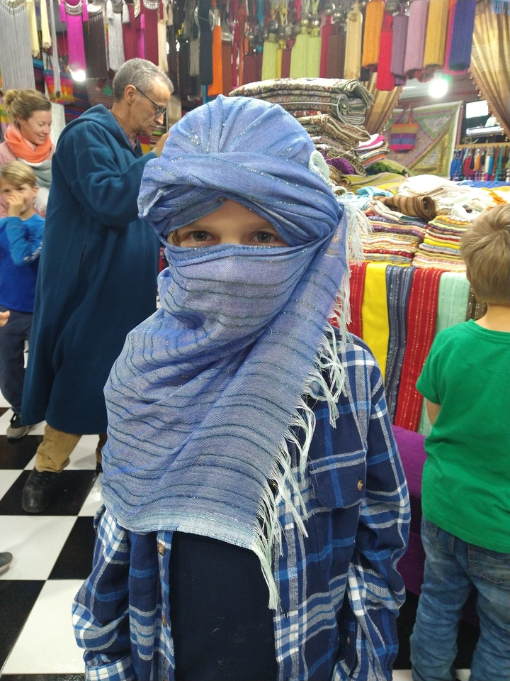 A person wearing a traditional headscarf in a shop.